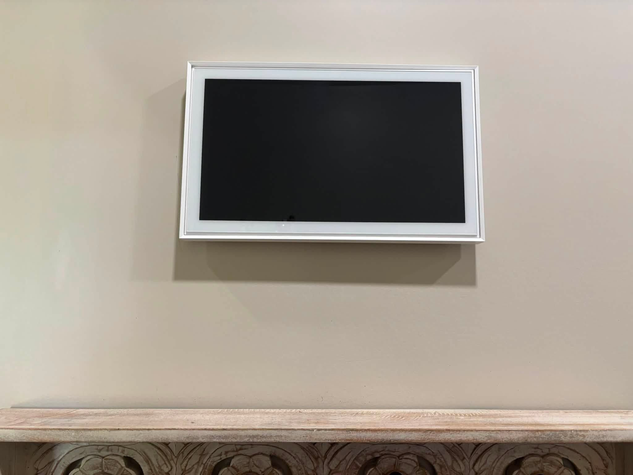 TV mounted on a beige wall with no visible cords